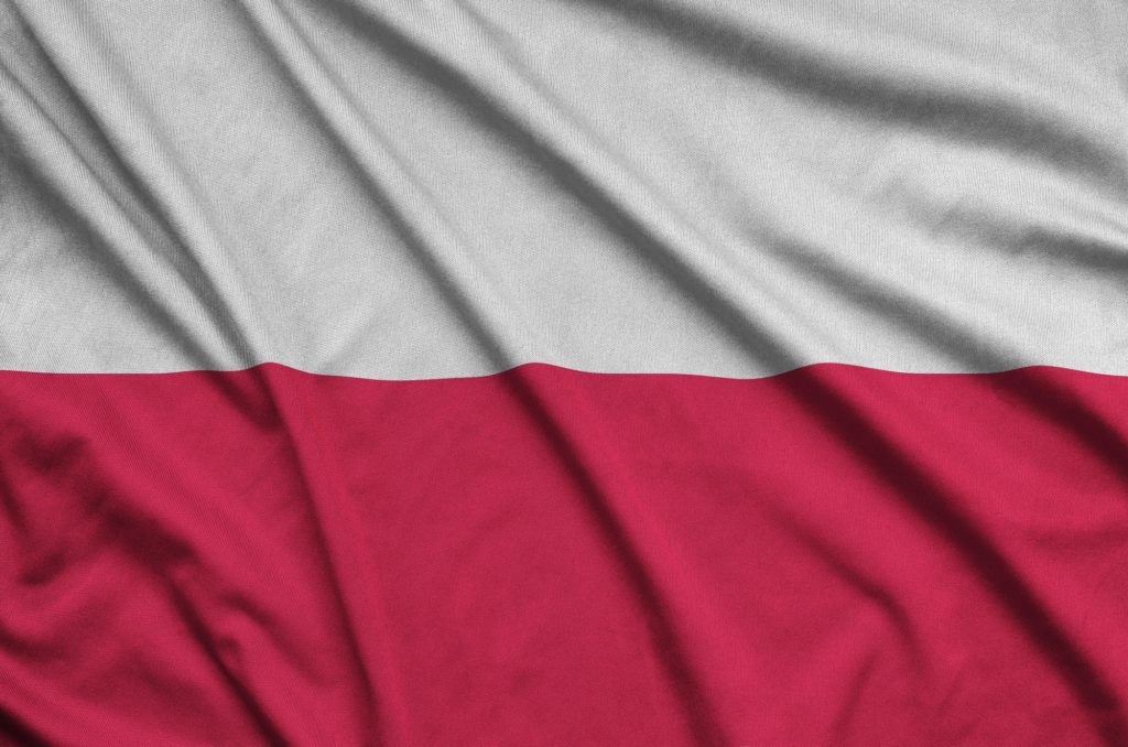 Die polnische Flagge ist auf einem Sportstoff mit vielen Falten abgebildet. Sportmannschaft winkt mit Fahne