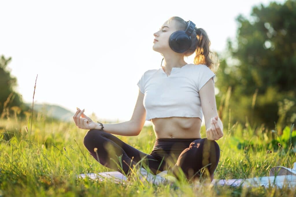Das Mädchen hört Musik über Kopfhörer. Eine Frau meditiert. Konzept für Lifestyle, Musik
